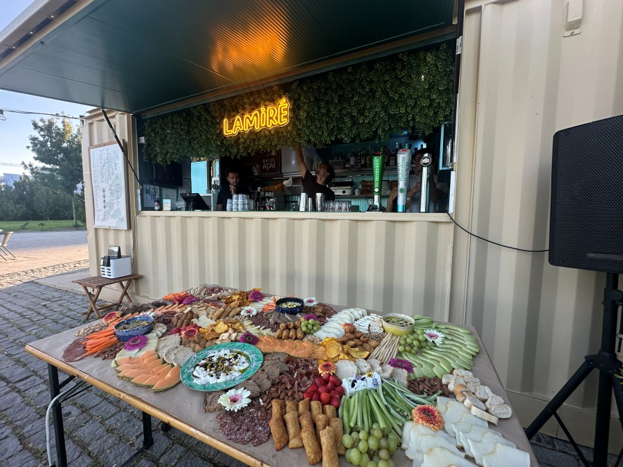 A grazing table laid out in front of a bar-container venue at dusk