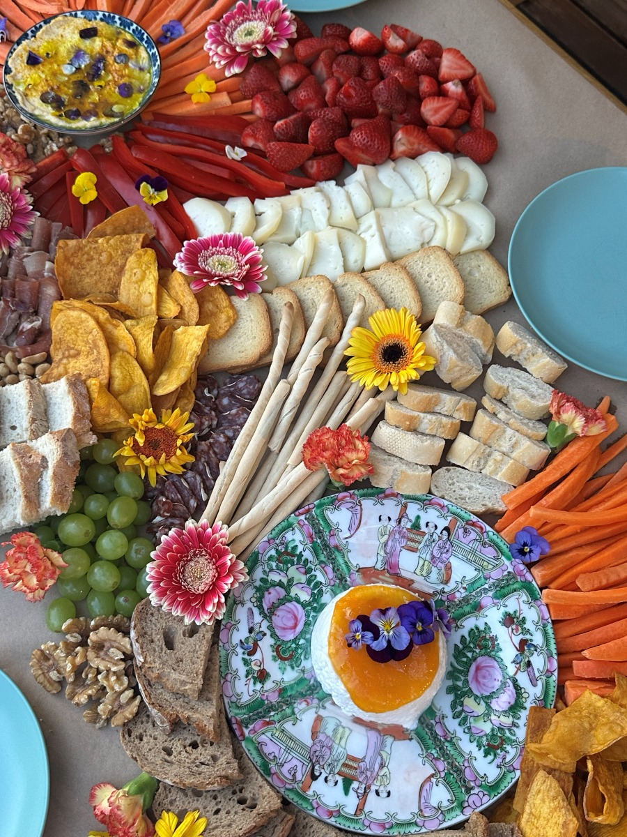 Overhead grazing table with strawberries, breads and a rose-pattern plate
